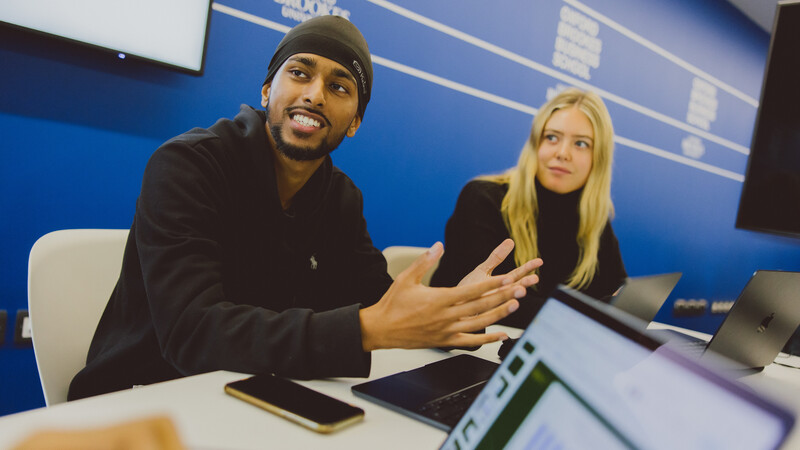 Two students listening to their tutor Two students listening to their tutor
